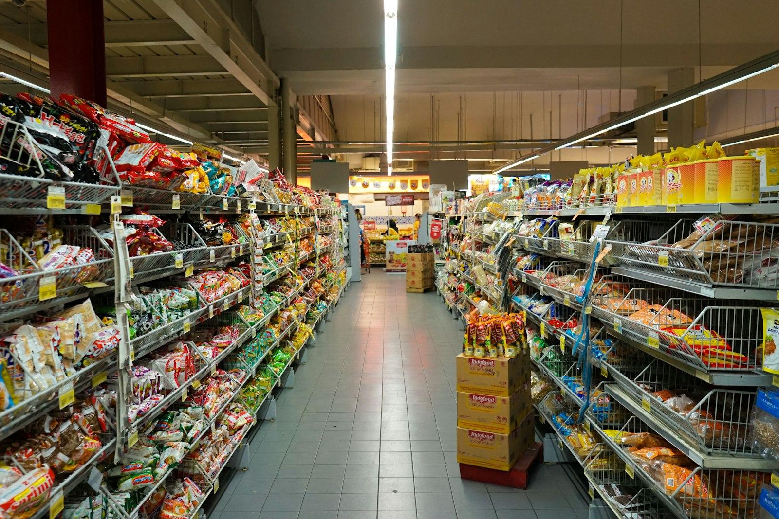 A grocery aisle with shelves of packaged food on both sides